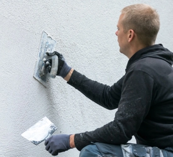 Handwerker verputzt Fassade Putz_ausbessern