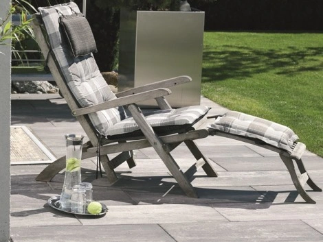Liegestuhl auf grauen Terrassenplatten Terrasse_Belag_Betonstein